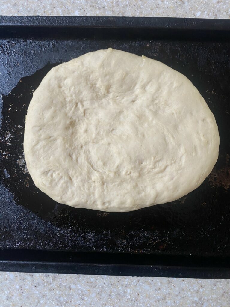 An unbaked focaccia bread, before applying olive oil. 