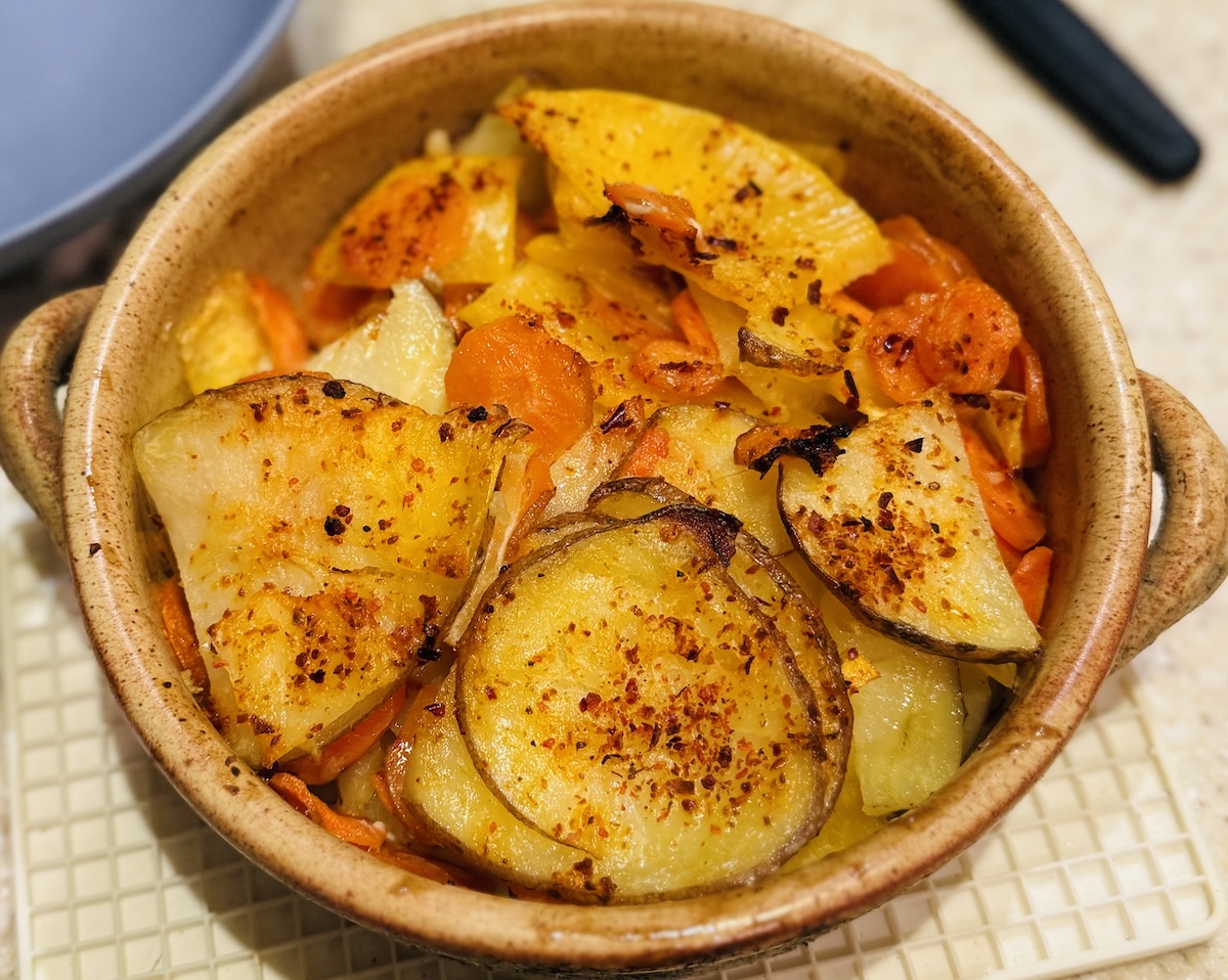 Budget root vegetable dauphinoise in an earthenware dish. 