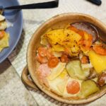 mixed vegetable dauphinoise in an earthenware dish.