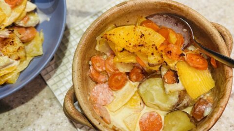 mixed vegetable dauphinoise in an earthenware dish.