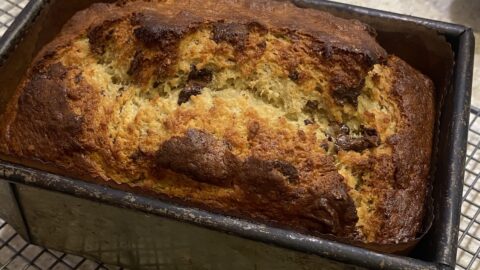 a close up picture of baked banana bread still min the loaf tin it was baked in.