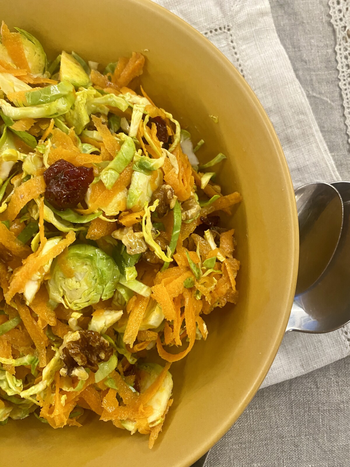 brussel sprout salad with cranberries in a mustard coloured bowl