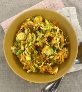 Raw Brussel sprout salad in a mustard coloured bowl