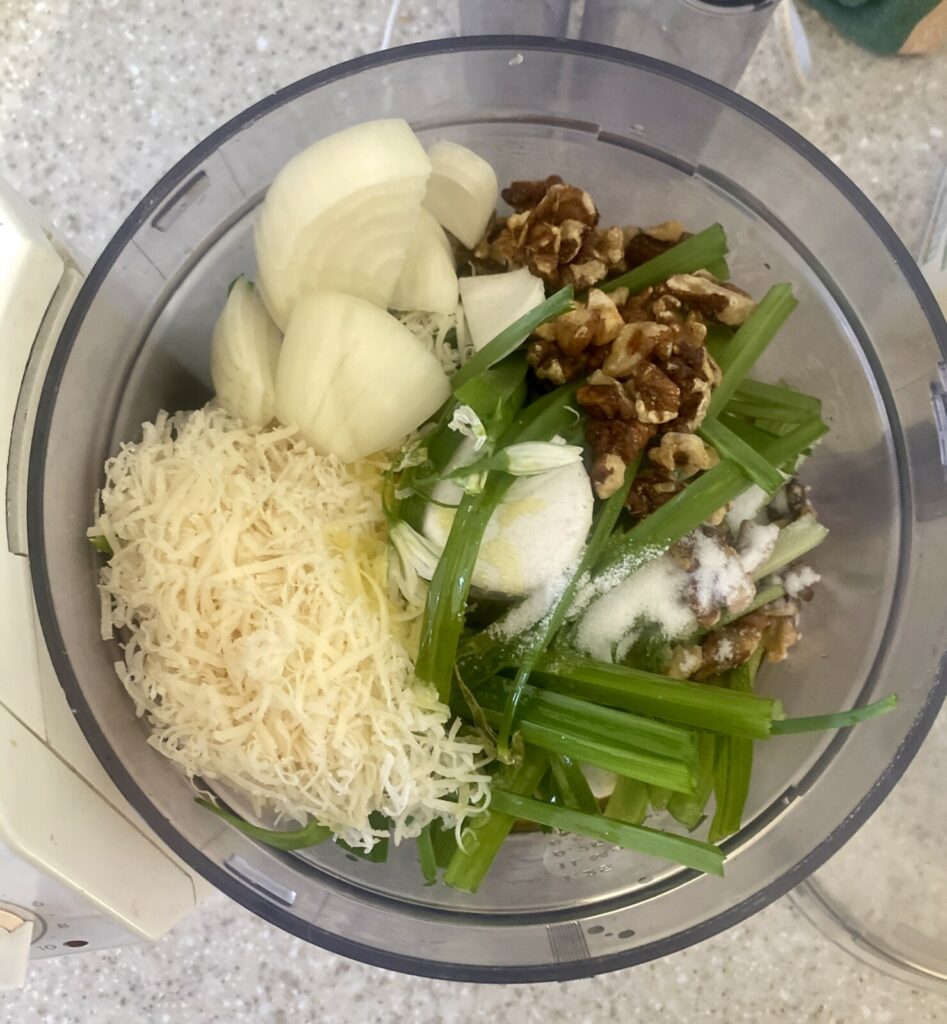 wild garlic pesto ingredients in a food processor bowl. 