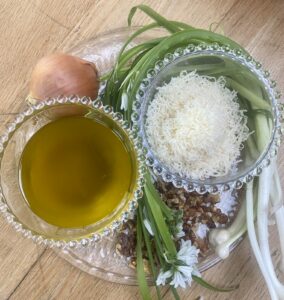 wild garlic pesto ingredients, on a glass plate.