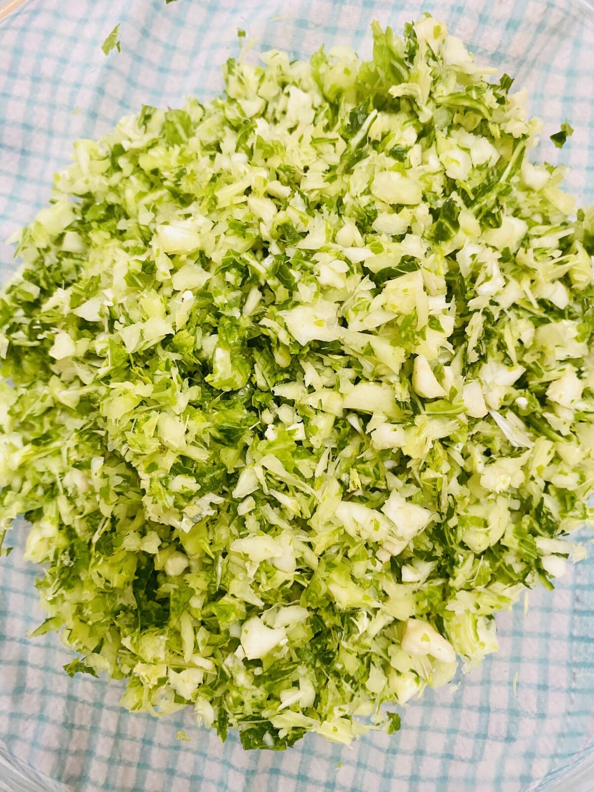 a glass bowl containing the shredded stems of 2 cauliflowers