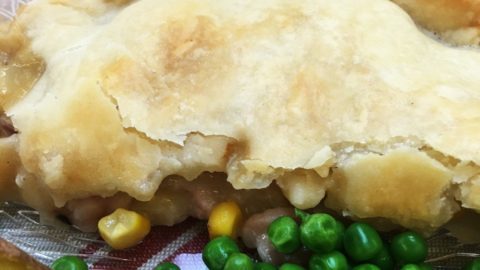 bacon and sweetcorn pie -on a plate, close up, with peas