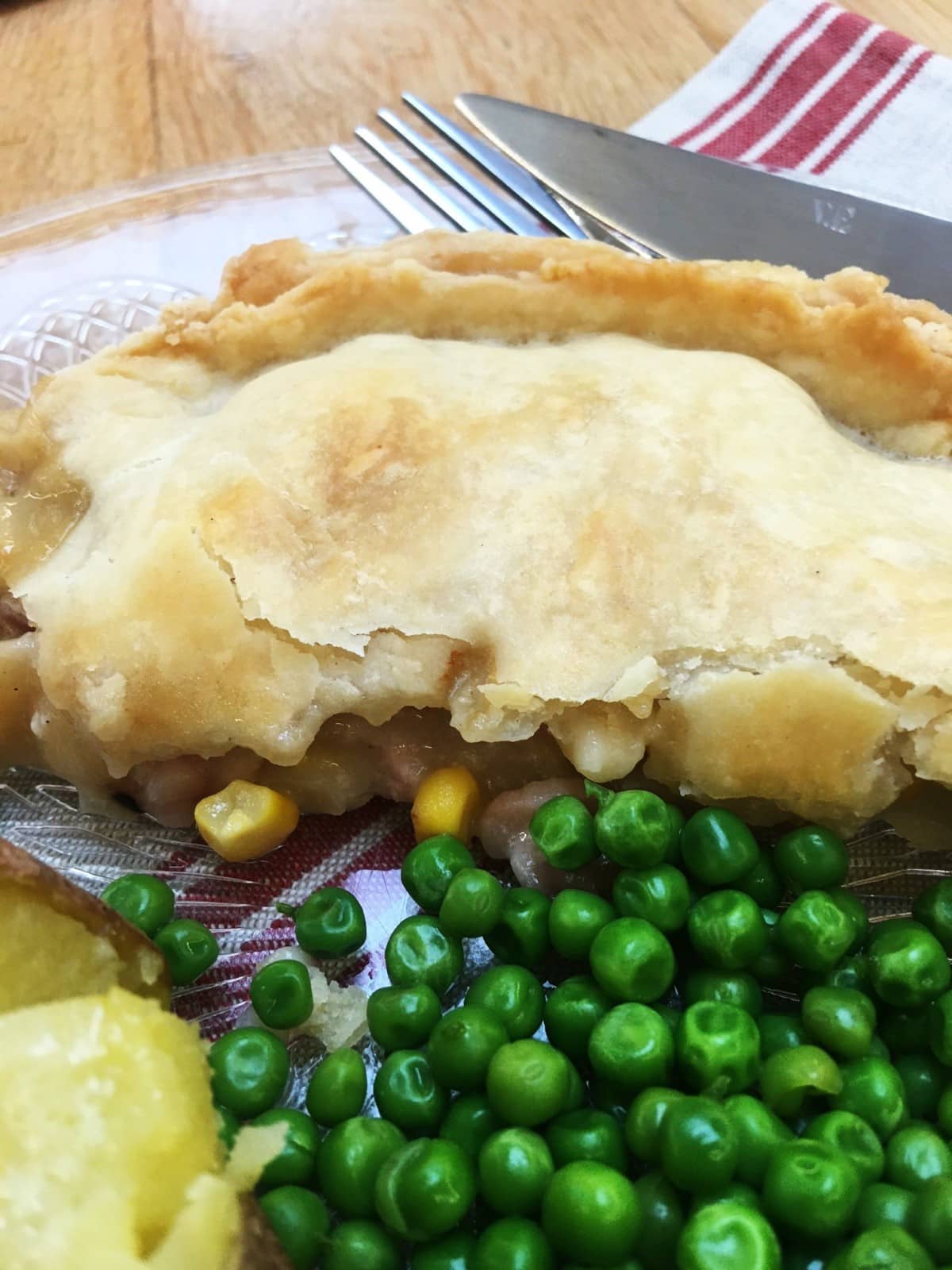 bacon and sweetcorn pie -on a plate, close up, with peas