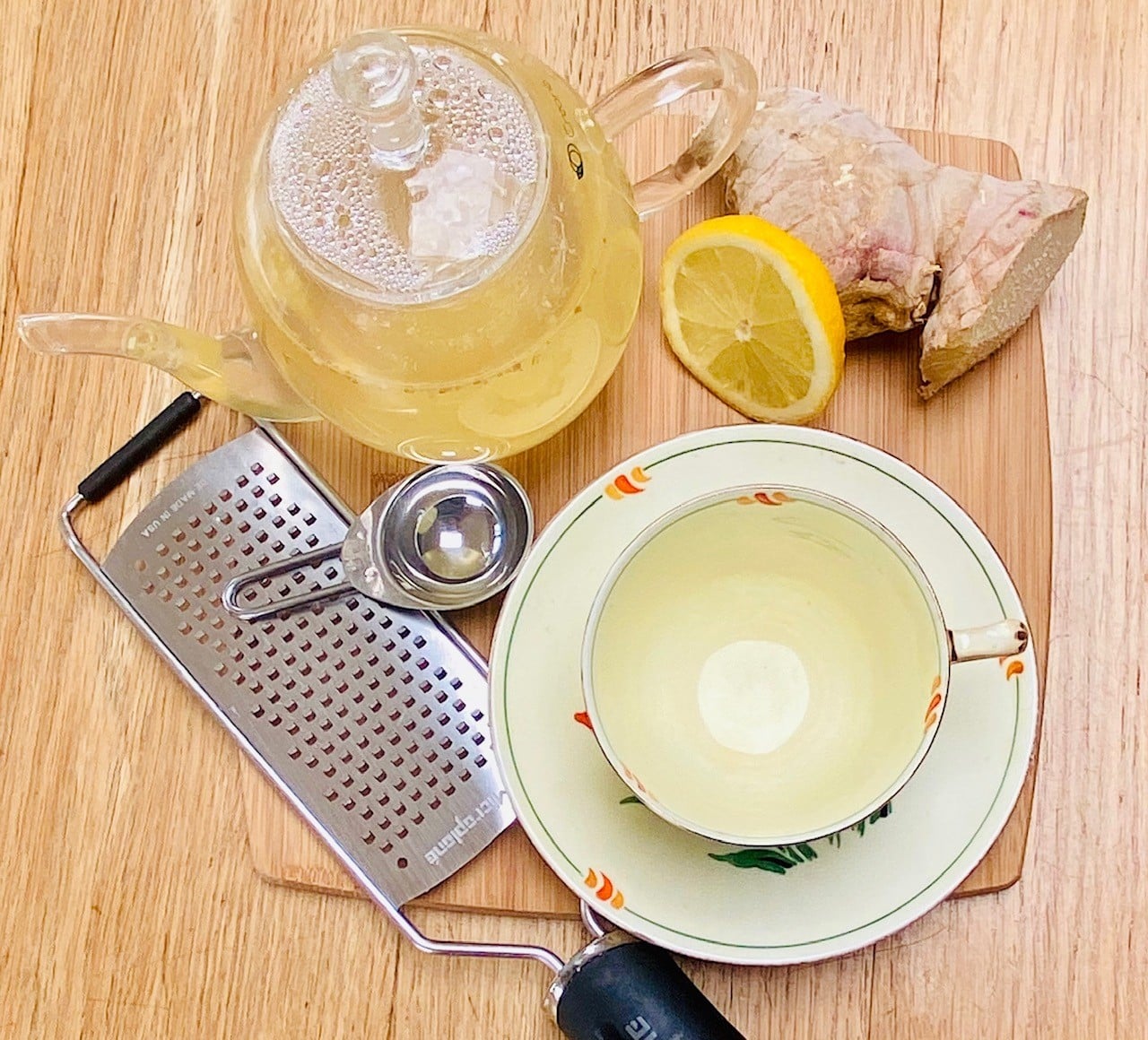 ginger tea in a glass tea pot, with grater and knob of ginger