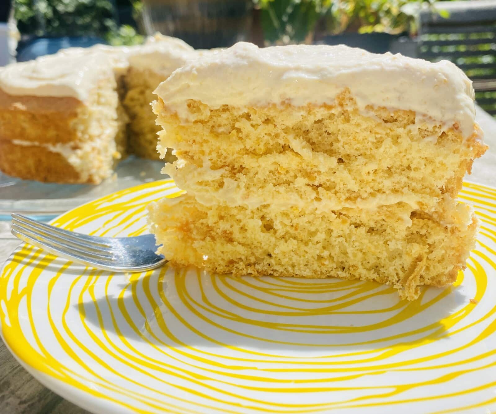 a slice of orange cake with cream cheese frosting