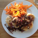 Olive drop scones, crispy fried onions and a carrot ribbon salad, on a white plate.