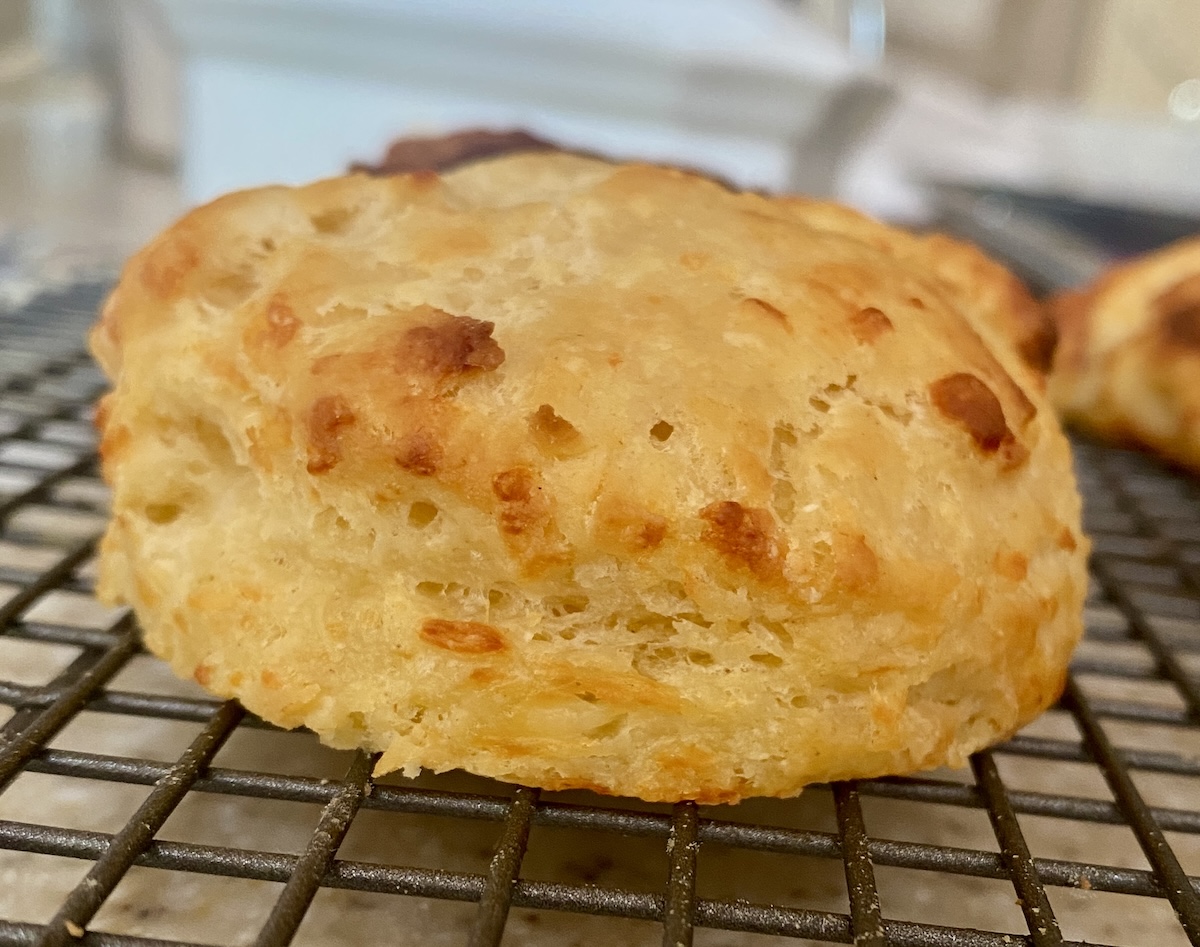 a cheese scone on a wire cooling rack. 