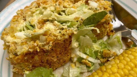 a slice of vegetable roulade on a plate with a corn cob.