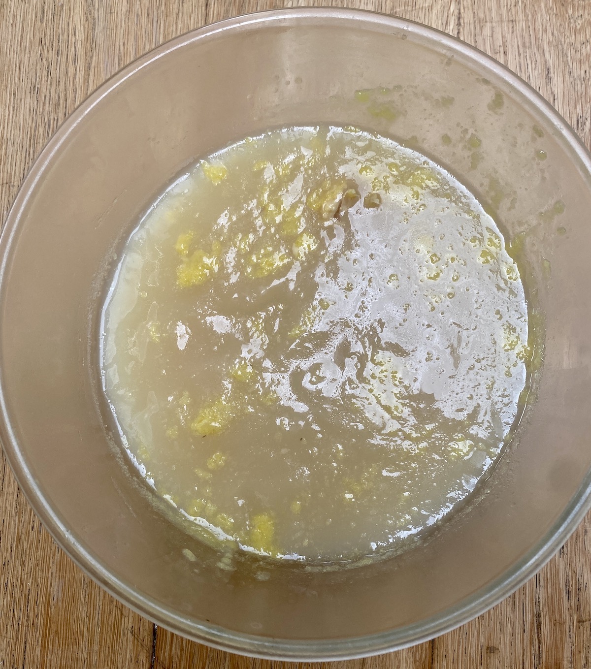 cold chicken stock in a clear pyrex mixing bowl.