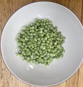 frozen peas in a white bowl.