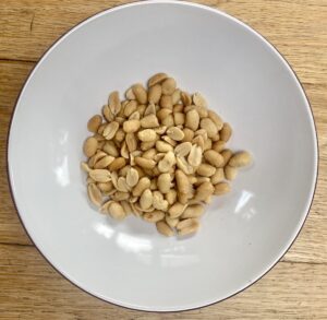 salted peanuts in a white bowl.