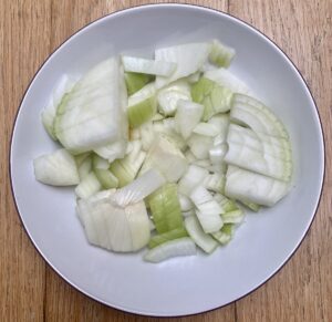 Onions, chopped, in a white bowl.