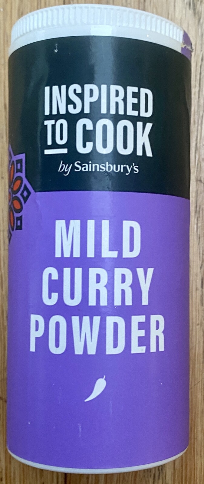 A tub of mild curry powder. The tub is coloured purple.