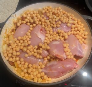 chicken thighs and chickpeas added to the pan.