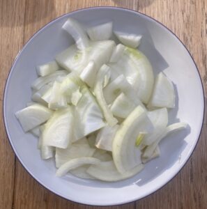 sliced onion in a white bowl.