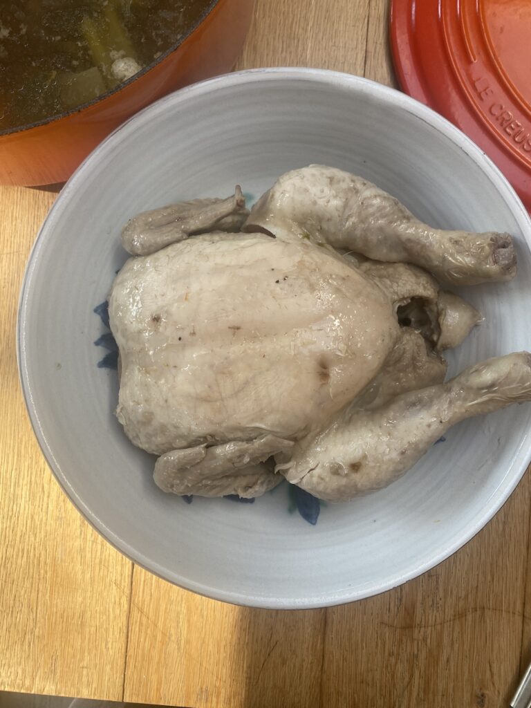 a poached chicken in a white bowl.