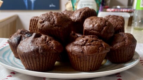 a pile of chocolate muffins on a plate.