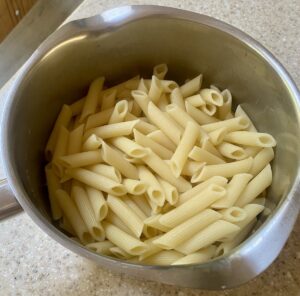 cooked pasta in a metal saucepan.