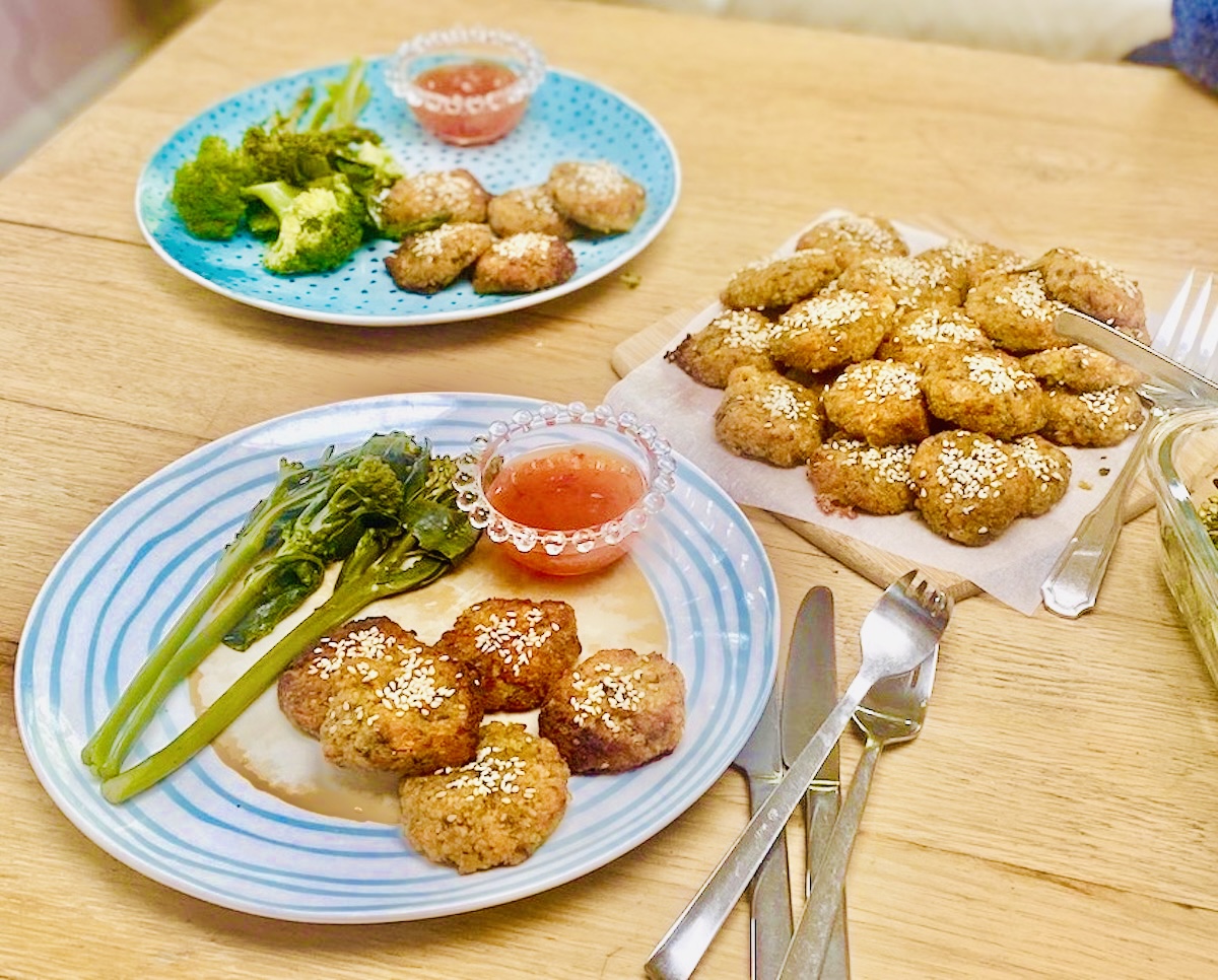 lentil patties on 2 dining plates, with vegetables and a dip.