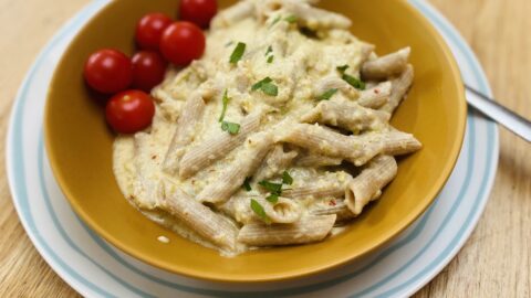 easy green tomato sauce in a mustard coloured bowl, on a blue striped plate.