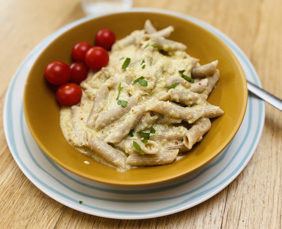 easy green tomato sauce in a mustard coloured bowl, on a blue striped plate. 