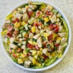 chicken and mango salad in a white dish