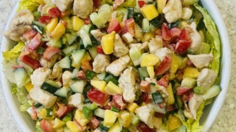 chicken and mango salad in a white dish