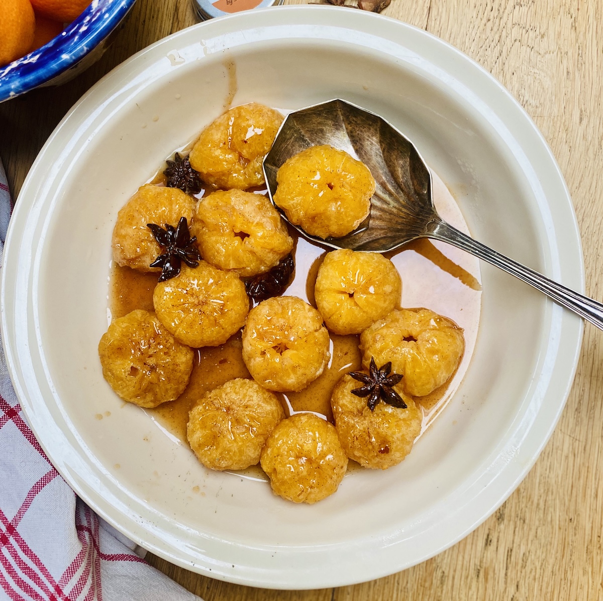 A cream coloured dish of spiced clementines.