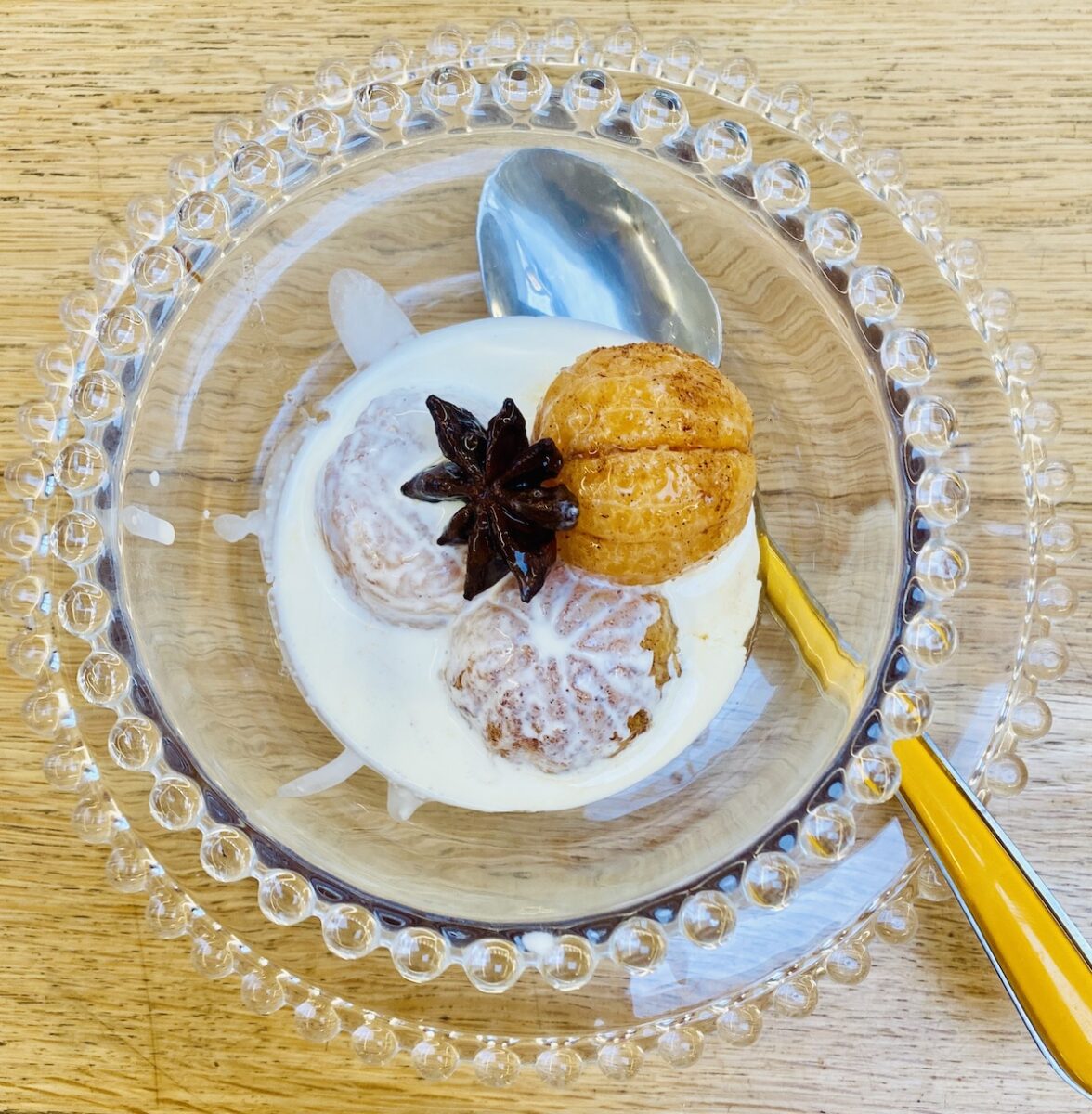 christmas clementines in a glass dish with a spoon, and on a glass plate. 