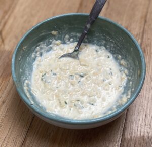 cheese and onion deli filling in a duck egg blue bowl, looking a little loose immediately after mixing.