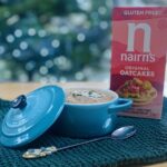 turkey liver pate in a small (250 ml) pale blue le creuset dish, on a green waffle tea-towel, with a box of oat cakes in at the background and a long handled tea spoon on the foreground