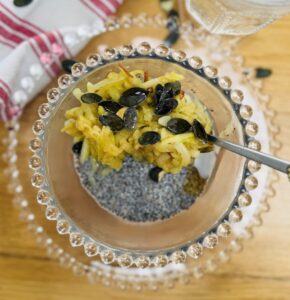chia pudding topped with grated apple and pumpkin seeds, with a trickle of maple syrup.