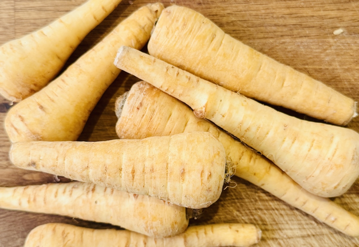 Unpeeled parsnips in a pile. 